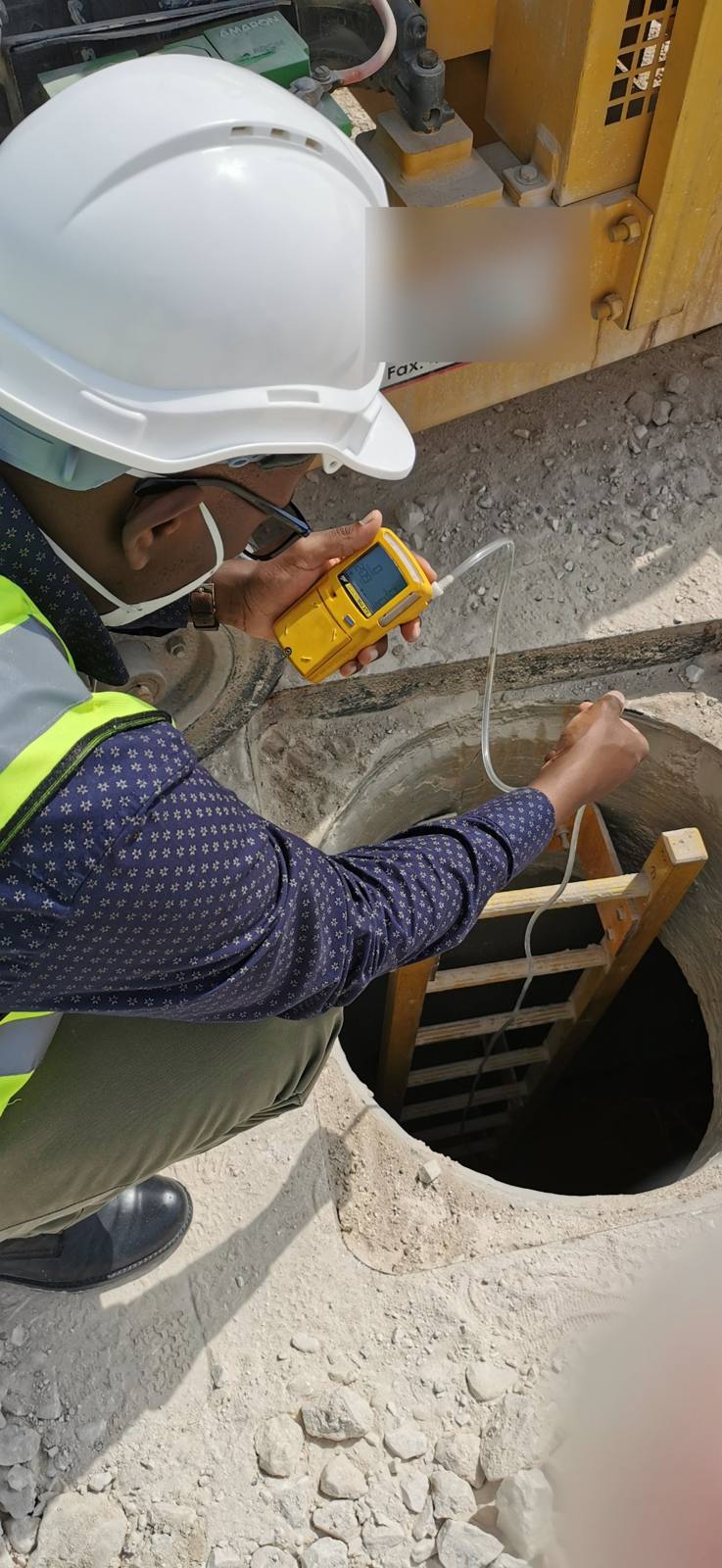 Joshua testing the atmosphere of a confined space with a gas detector